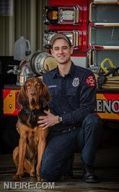 NLFD Search and Rescue K9, Bo, and his handler, Firefighter Paramedic John Ruckman in front of fire engine.